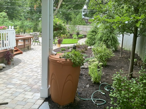 Landscape Design With Paver Patio, Water Features, Landscape Lighting, Rain Barrel & New Plantings in Rochester NY By Acorn Ponds & Waterfalls - Contact us now to get started on your escape! Image