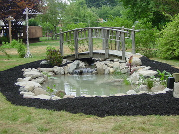 Backyard pond construction with bridges in Rochester New York (NY) By Acorn Ponds & Waterfalls.